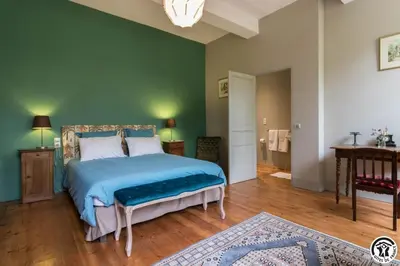 a bedroom with a bed with a blue comforter at Chateau sud in Cessales