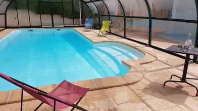 a swimming pool with two chairs and a table and a tablektop at La maison imart in Revel