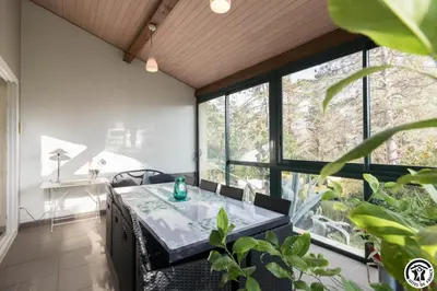 a dining room with a table and large windows at La maison imart in Revel