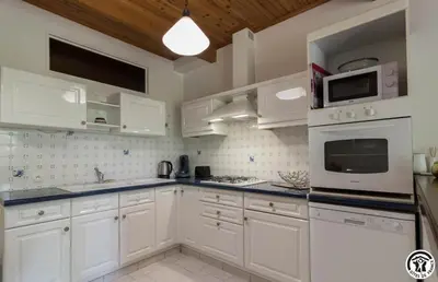 a white kitchen with white cabinets and appliances at La cajole in Montgaillard-Lauragais