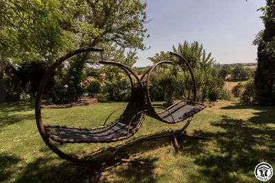 a metal sculpture of a bench in the grass at La cajole in Montgaillard-Lauragais