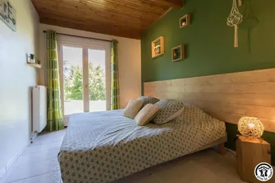 a bedroom with green walls and a bed with pillows at La cajole in Montgaillard-Lauragais