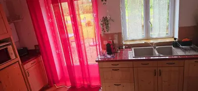 a kitchen with pink curtains and a sink at Gîte Domaine de la Fée de l'Eau – L'Eau d'Ô in Saint-Félix-Lauragais