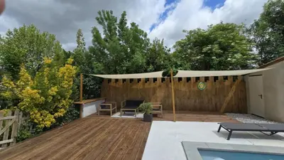 a backyard with a wooden deck and a pergola at Gîte Domaine de la Fée de l'Eau – L'Eau d'Ô in Saint-Félix-Lauragais