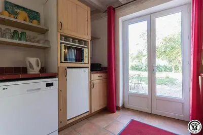a kitchen with a white refrigerator and a door at Domaine de la fee de l'eau - les fees de l'o in Saint-Félix-Lauragais