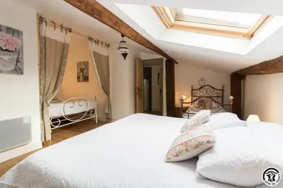 a bedroom with a bed with white sheets and pillows at Domaine de la fee de l'eau - les fees de l'o in Saint-Félix-Lauragais