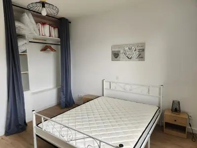 a small bedroom with a white bed and a money at Appartement refait à neuf in Villeneuve-la-Comptal