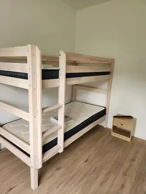 two wooden bunk beds in a room with wooden floors at Appartement refait à neuf in Villeneuve-la-Comptal