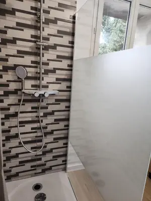 a bathroom with a shower with a glass door at Appartement refait à neuf in Villeneuve-la-Comptal