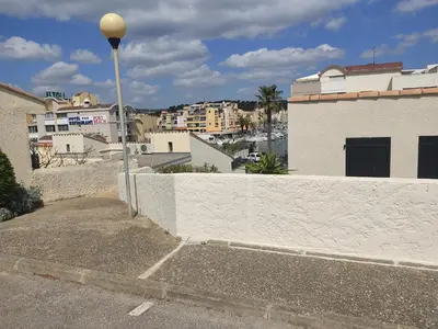 a street light on the side of a wall with buildings at Villa Climatisée 6 Pers - Proche Port & Village - Parking Privé - FR-1-796-88 in Gruissan