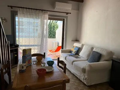 a living room with a white couch and a table at Villa Climatisée 6 Pers - Proche Port & Village - Parking Privé - FR-1-796-88 in Gruissan