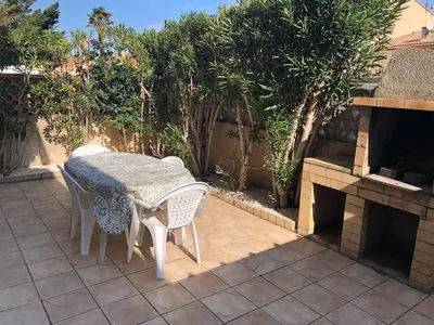 a table and chairs on a patio with a fireplace at Maison T5 110m² avec jardin clos, près de la plage, animaux acceptés, parking - FR-1-797-64 in Port-la-Nouvelle