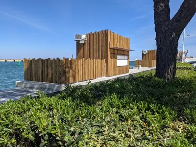 a wooden building next to a tree next to the water at Maison T5 110m² avec jardin clos, près de la plage, animaux acceptés, parking - FR-1-797-64 in Port-la-Nouvelle