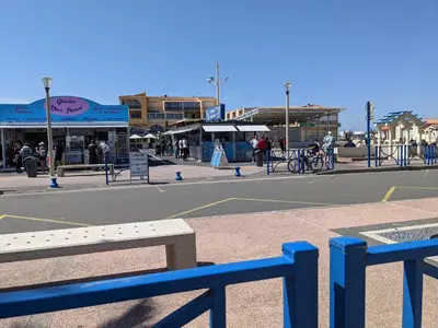 a blue bench in front of a city street at Maison T5 110m² avec jardin clos, près de la plage, animaux acceptés, parking - FR-1-797-64 in Port-la-Nouvelle