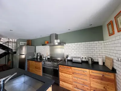 a kitchen with a stove and a sink in it at Maison Standing - Exceptionnel in Roquefort-des-Corbières