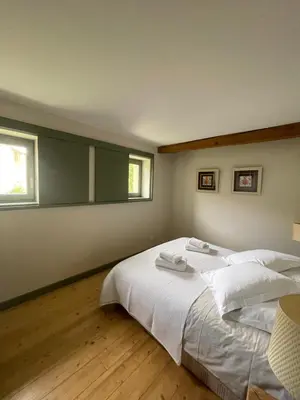 a bedroom with a large white bed and two windows at Maison Standing - Exceptionnel in Roquefort-des-Corbières