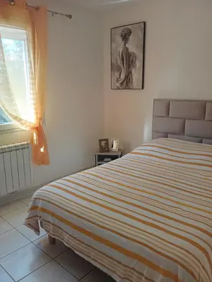 a bedroom with a bed with a striped blanket at Chez Lia in Rieux-Minervois