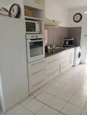 a kitchen with white cabinets and a microwave at Chez Lia in Rieux-Minervois