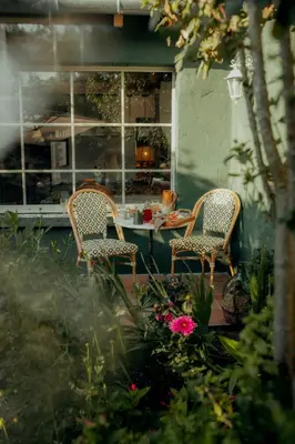 a patio with two chairs and a table with flowers at Cozy And Refined Retreat In The Heart Of Fanjeaux in Fanjeaux