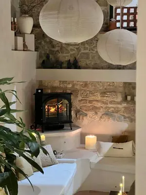 a living room with a fireplace and two white lamps at Cozy And Refined Retreat In The Heart Of Fanjeaux in Fanjeaux