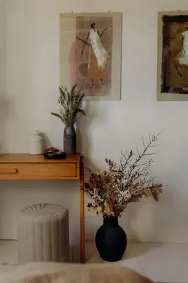a room with a table and a vase with flowers at Cozy And Refined Retreat In The Heart Of Fanjeaux in Fanjeaux
