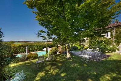 a yard with chairs and a tree and a pool at Character House Between Toulouse And Carcassonne in Soupex