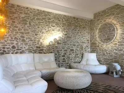 a living room with white furniture and a stone wall at Character House Between Toulouse And Carcassonne in Soupex