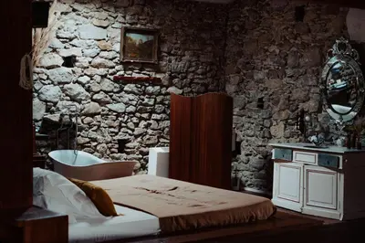a bedroom with a bed and a stone wall at Artistic Loft Near Carcassonne in Cavanac