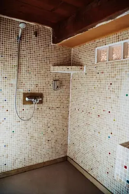 a bathroom with a shower with white tiled walls at Artistic Loft Near Carcassonne in Cavanac