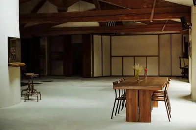 a wooden table and chairs in a large room at Artistic Loft Near Carcassonne in Cavanac