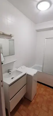 a white bathroom with a sink and a tub at Le Nova blue les pieds dans l'eau in Port-la-Nouvelle