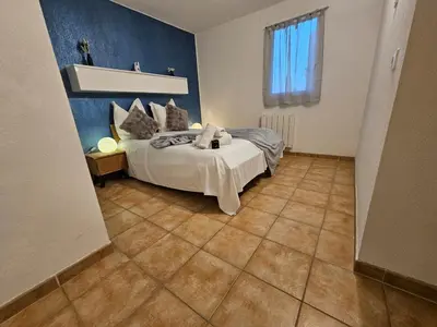 a bedroom with a bed and a tile floor at Logis de Gaia YourHostHelper in Homps