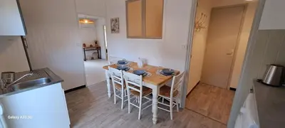 a kitchen with a table and chairs in a room at Maison Calme au Centre du Village in Puisserguier