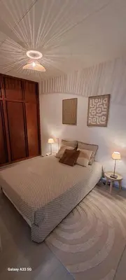 a bedroom with a large bed and two lamps at Maison Calme au Centre du Village in Puisserguier