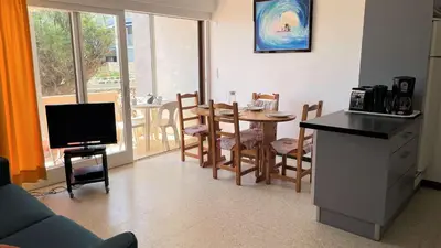 a living room with a kitchen and a table with a television at Appartement 2 pièces PORT LA NOUVELLE PN015-003 in Port-la-Nouvelle