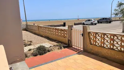 a fence next to a beach with cars on it at Appartement 2 pièces PORT LA NOUVELLE PN015-003 in Port-la-Nouvelle