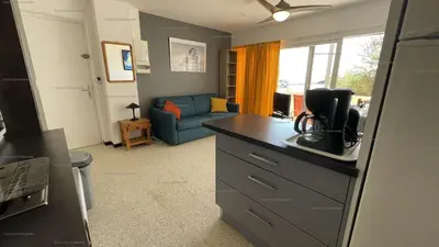 a kitchen and living room with a blue couch at Appartement 2 pièces PORT LA NOUVELLE PN015-003 in Port-la-Nouvelle
