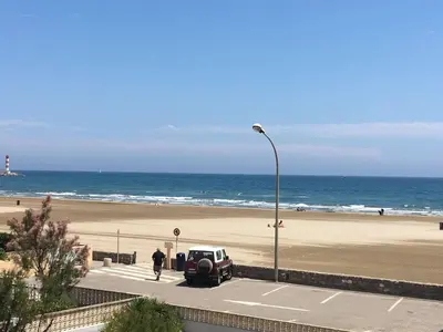 a car parked in a parking lot next to a beach at Appartement 2 pièces PORT LA NOUVELLE PN015-003 in Port-la-Nouvelle