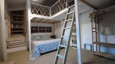 a bedroom with a bunk bed and a ladder at Le gîte du moulin in Thézan-des-Corbières