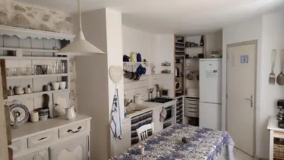 a kitchen with a sink and a refrigerator at Le gîte du moulin in Thézan-des-Corbières