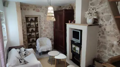 a living room with a couch and a fireplace at Le gîte du moulin in Thézan-des-Corbières