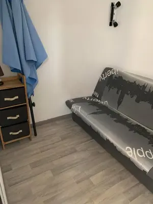 a bedroom with a bed and a dresser in it at Petite maisonnette de vacances in Gruissan