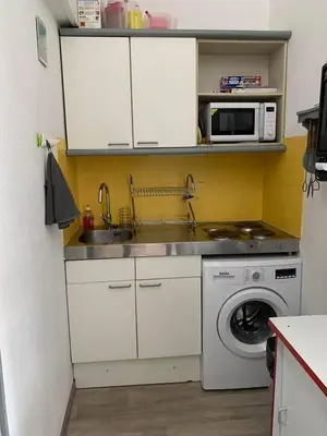 a kitchen with a sink and a washing machine at Petite maisonnette de vacances in Gruissan