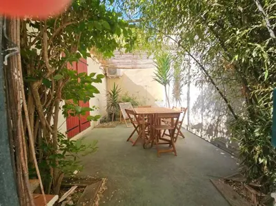 a patio with a table and chairs and trees at La Tiny House YourHostHelper in Narbonne