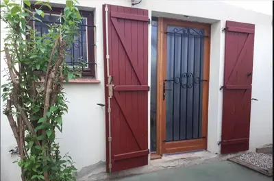 a pair of red doors on the side of a building at La Tiny House YourHostHelper in Narbonne