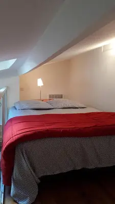 a bedroom with a large bed with a red blanket at La Tiny House YourHostHelper in Narbonne