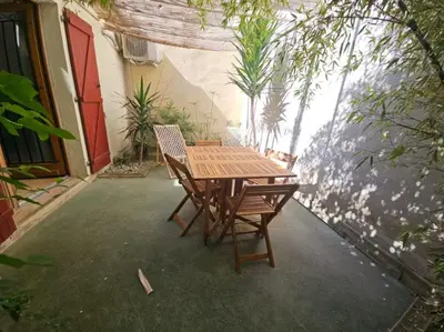 a wooden table and chairs on a patio at La Tiny House YourHostHelper in Narbonne