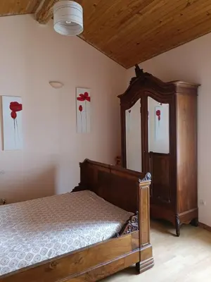 a bedroom with a wooden bed and a dresser at Domaine Puy Saint Jammes in Castres