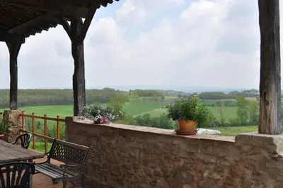a balcony with a table and chairs and a view at Domaine Puy Saint Jammes in Castres