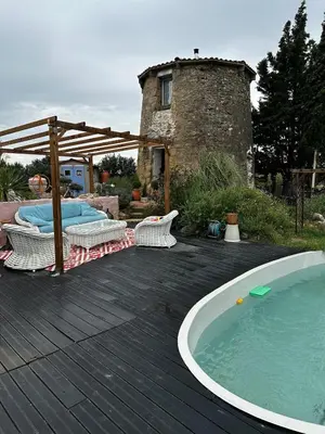 a wooden deck with a hot tub and a building at Moulin du Sud in Lafage